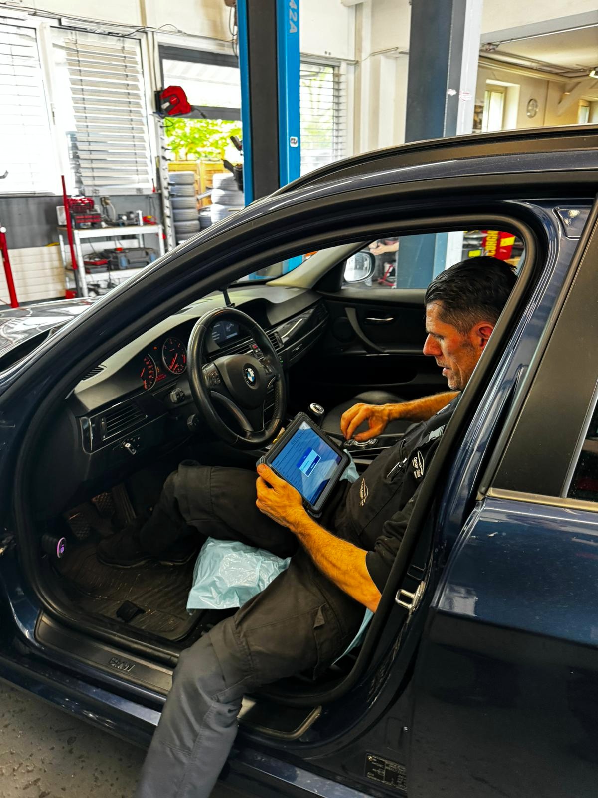 Sevdail Latifi liest im Fahrzeug den Fehlerspeicher mit einem Diagnosegerät aus